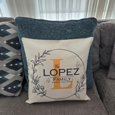Family name pillow cover styled on a sofa with other cushions