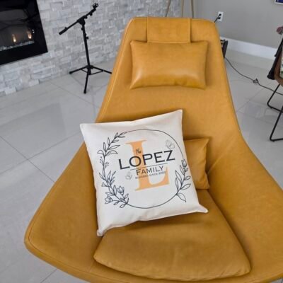 Family name pillow cover on a mustard lounge chair